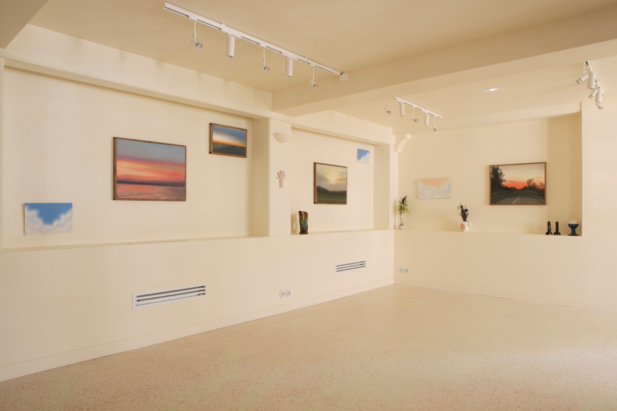 Una galería amplia con obras de arte en las paredes y un diseño limpio y minimalista.