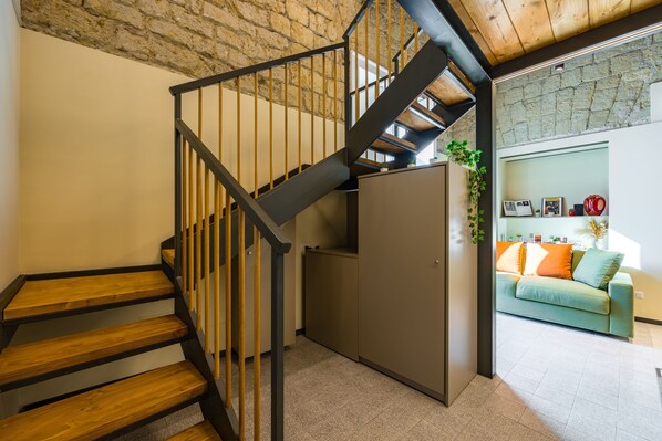 A staircase with wooden steps and black railings leading to a landing.