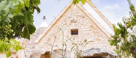 A stone building with a triangular roof and a small window.