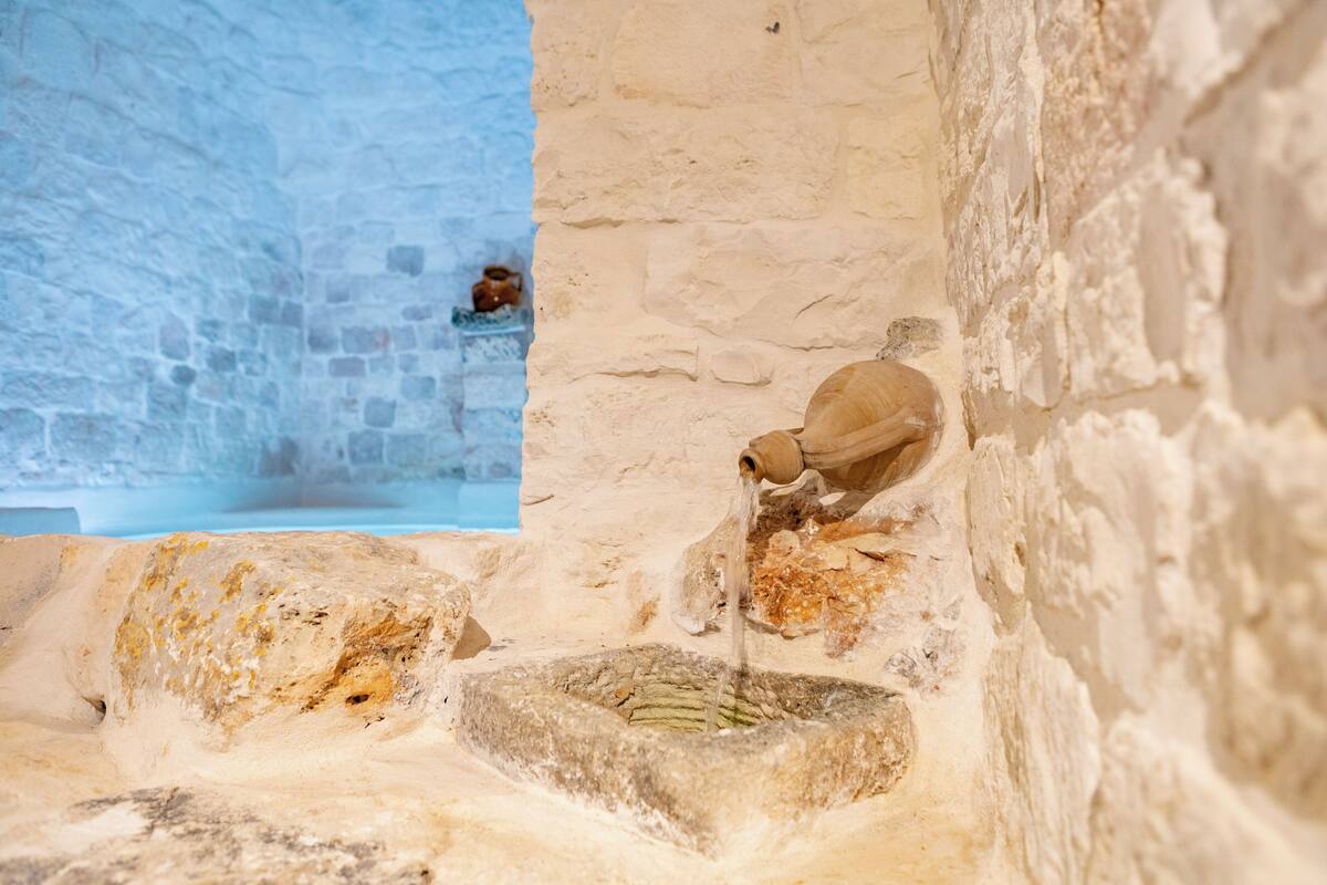 Una bodega con un pozo de agua y un muro de piedra.