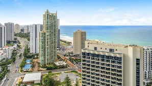 A high-rise building with a view of the ocean and other buildings.