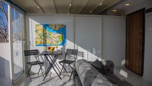 A modern room with a large window, a map on the wall, a sofa, and a table with drinks. - TERRACE FLAT AT THE CENTER OF OLD CITY WITH JACUZZI (Istanbul)