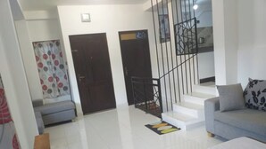 Un salon moderne avec un canapé, un escalier et une porte.