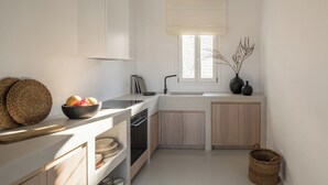 Une cuisine moderne équipée d’un four encastré, d’un évier et d’une fenêtre donnant sur l’extérieur.