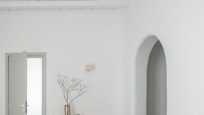 A minimalist bedroom with a bed, a desk, and a chair.