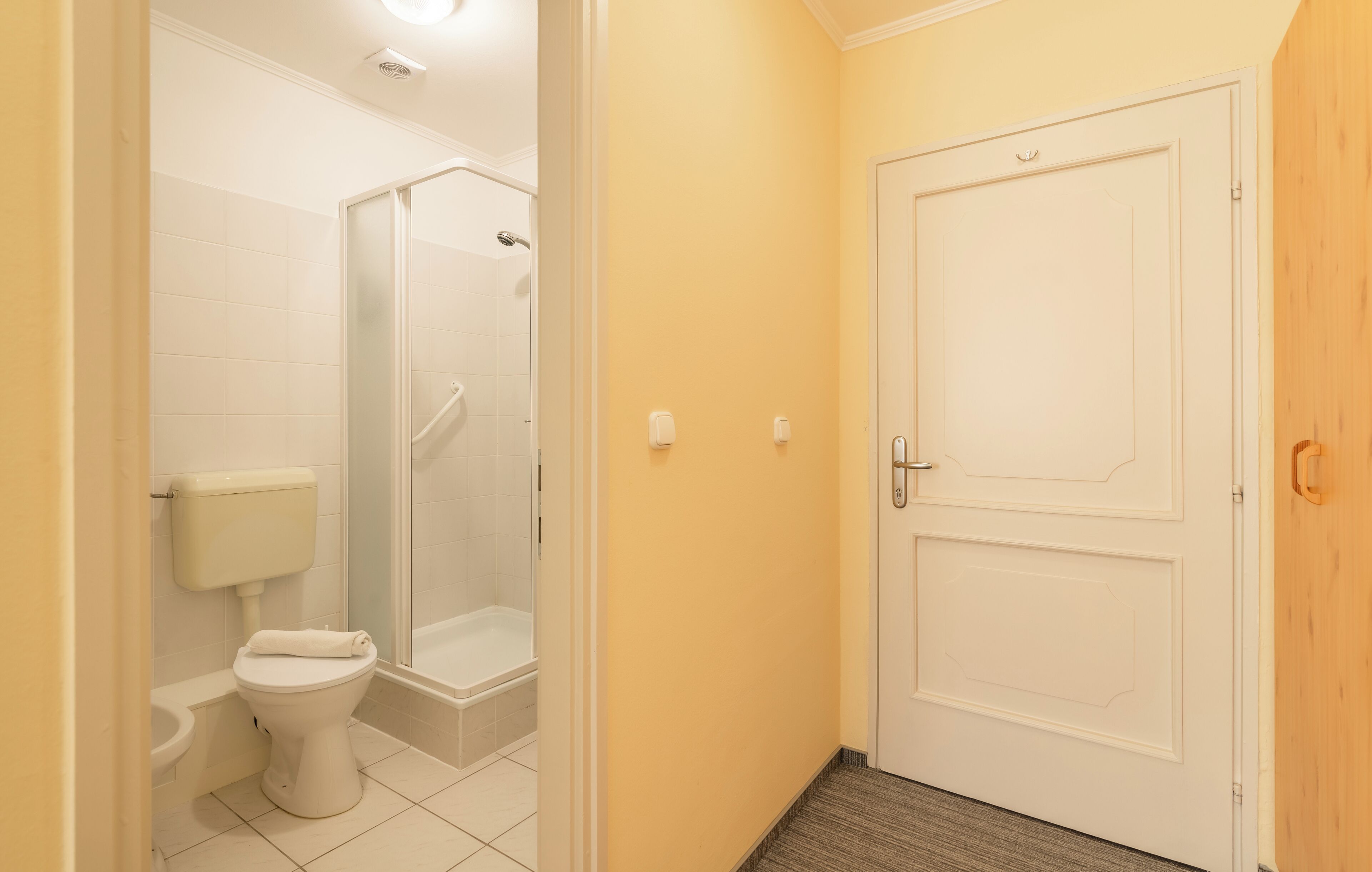 Un baño con inodoro, ducha y puerta.