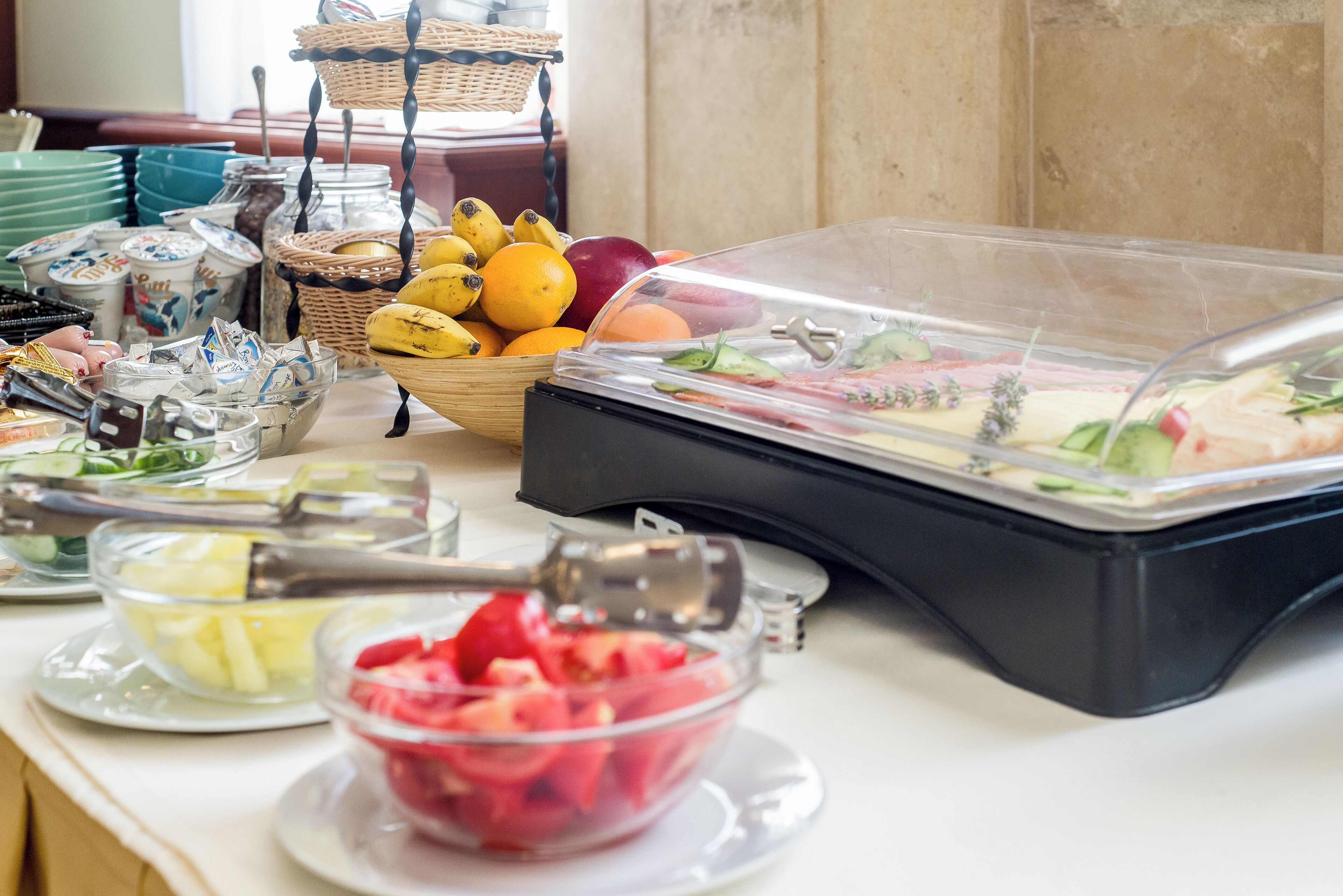 A buffet table with various food items and utensils.