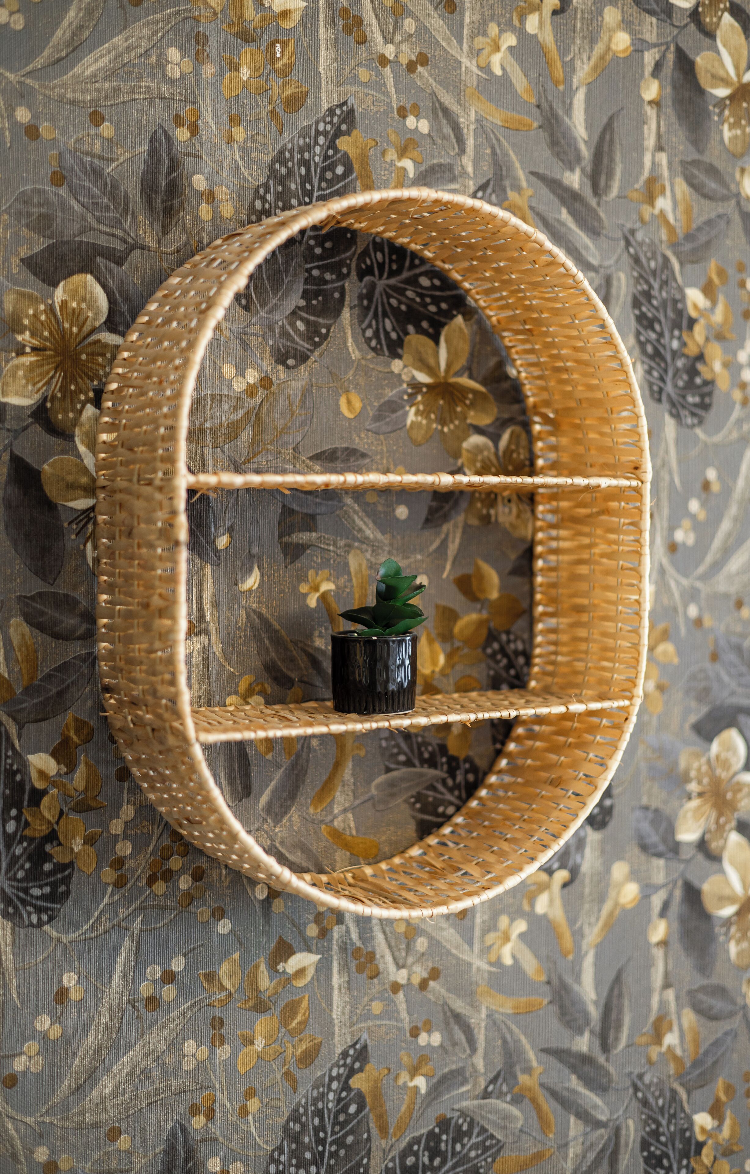 A wicker wall shelf with a small potted plant.