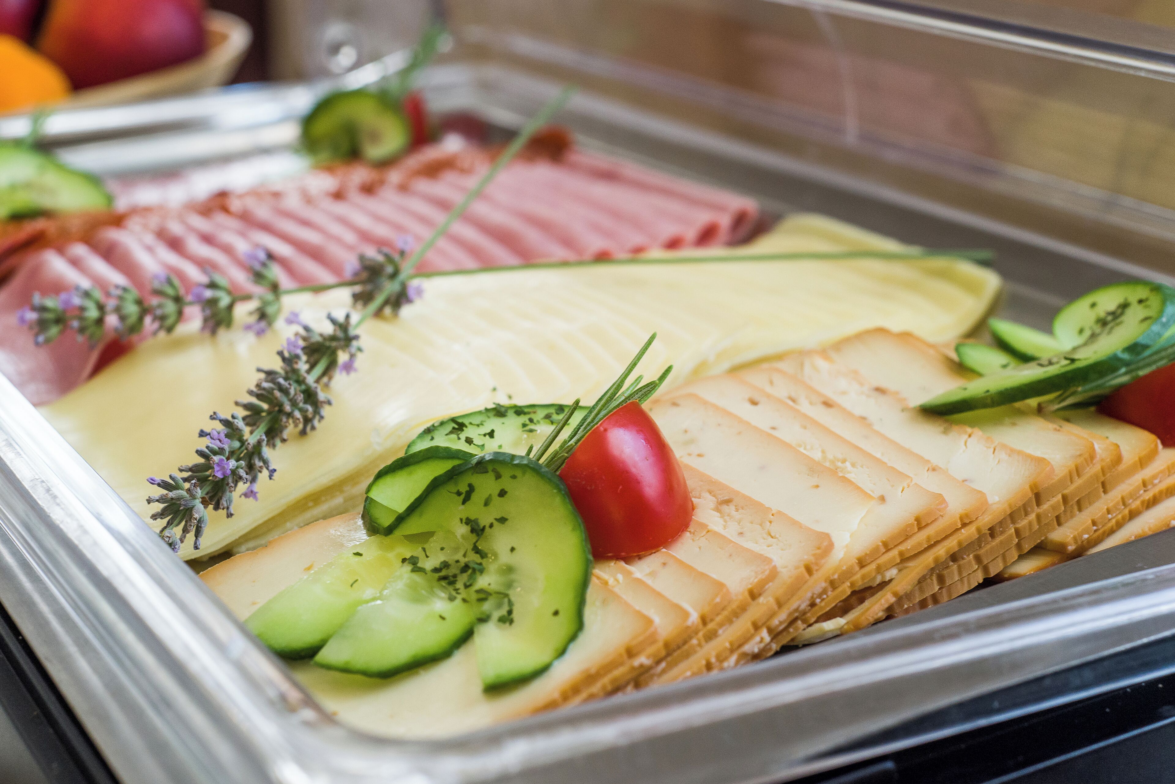 Un buffet con diverse pietanze, tra cui salumi, formaggi e verdure.