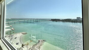 A view of a beach with a bridge in the background.