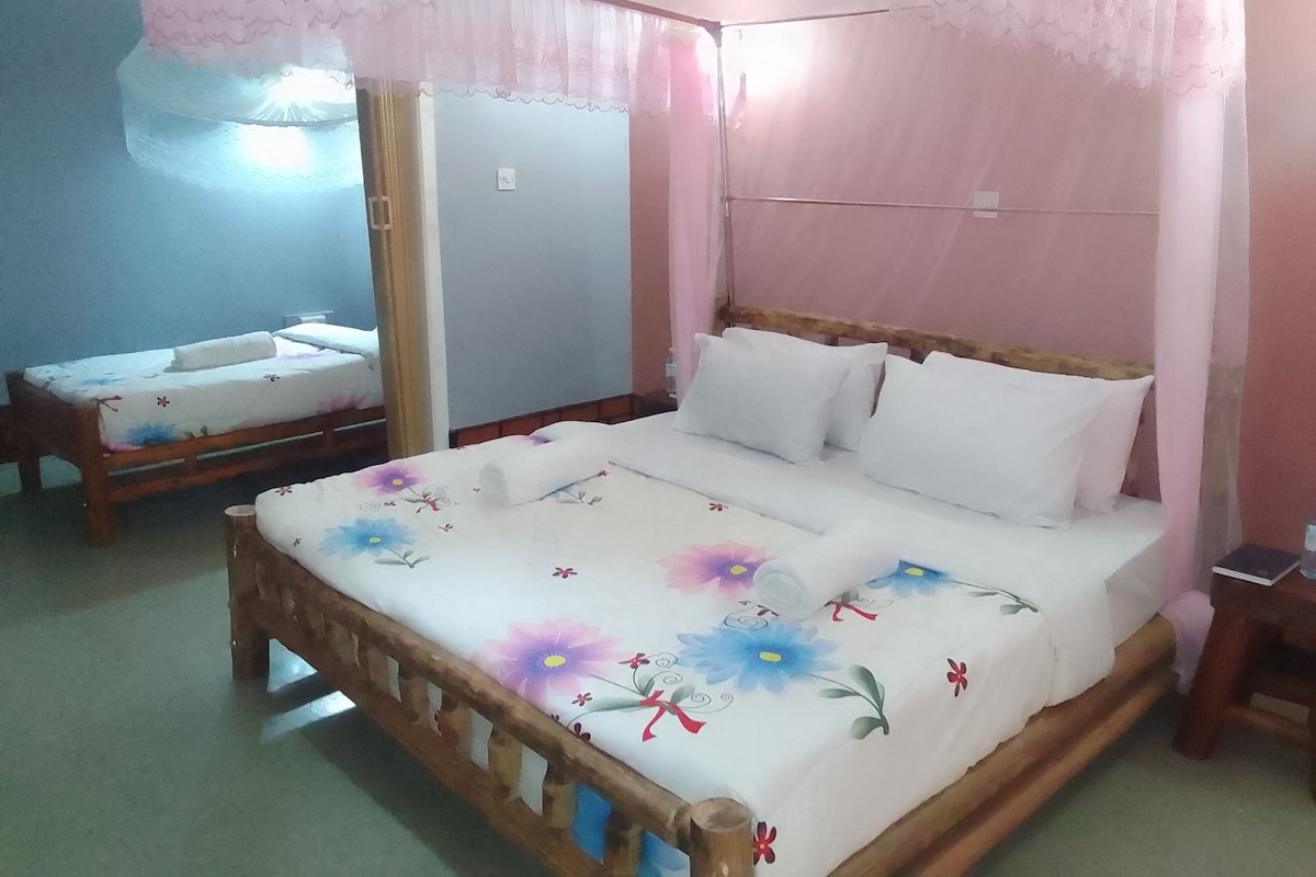 A room with a bed, a bedside table, and a mirror.