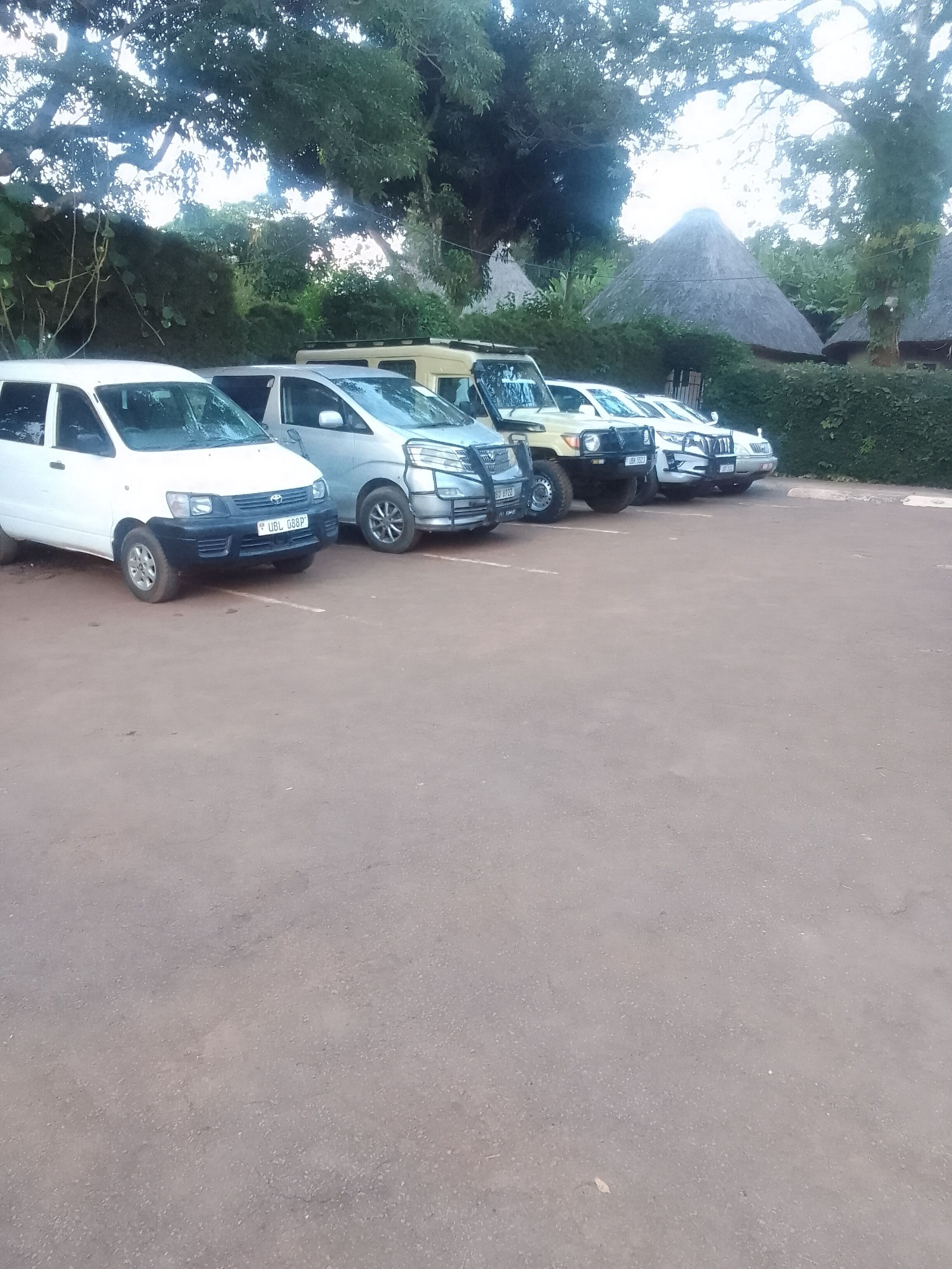 A parking lot with several cars parked in a row.