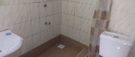 A bathroom with a shower, toilet, and sink.