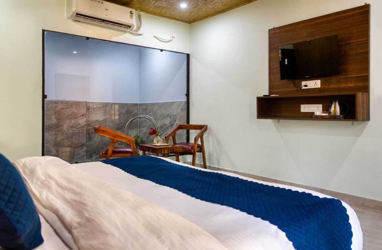 Une chambre à coucher comprenant un lit, une chaise, un téléviseur et une étagère fixée au mur.