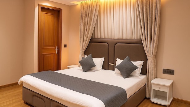 A bedroom with a large bed, a wooden door, and a bedside table.