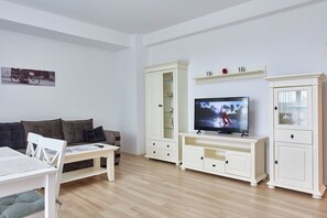 Apartamento Confort | Zona de estar | Televisión de pantalla plana de 110 cm con canales por cable
