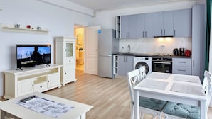 Un appartement moderne comprenant une cuisine, un coin repas et un salon.
