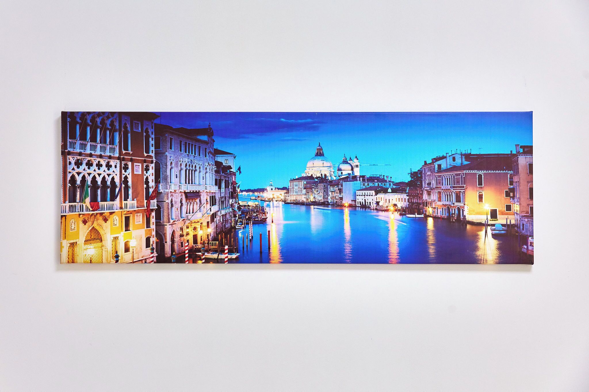 A panoramic view of a canal with historic buildings and a prominent dome structure.