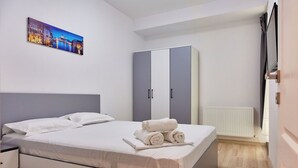 Une chambre à coucher avec un lit, une armoire, un tableau et un radiateur.