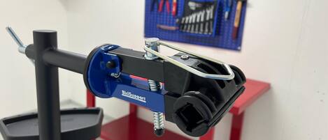 Un soporte para reparación de bicicletas BiciSupport azul con abrazadera de manillar negra y una base roja y negra.