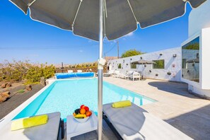 A swimming pool with lounge chairs, a fruit bowl, and a covered umbrella. - The View in T as With 4 Bedrooms and 4 Bathrooms (Tías)