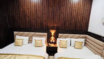 A hotel room with two beds, a ceiling fan, and a wooden wall panel.