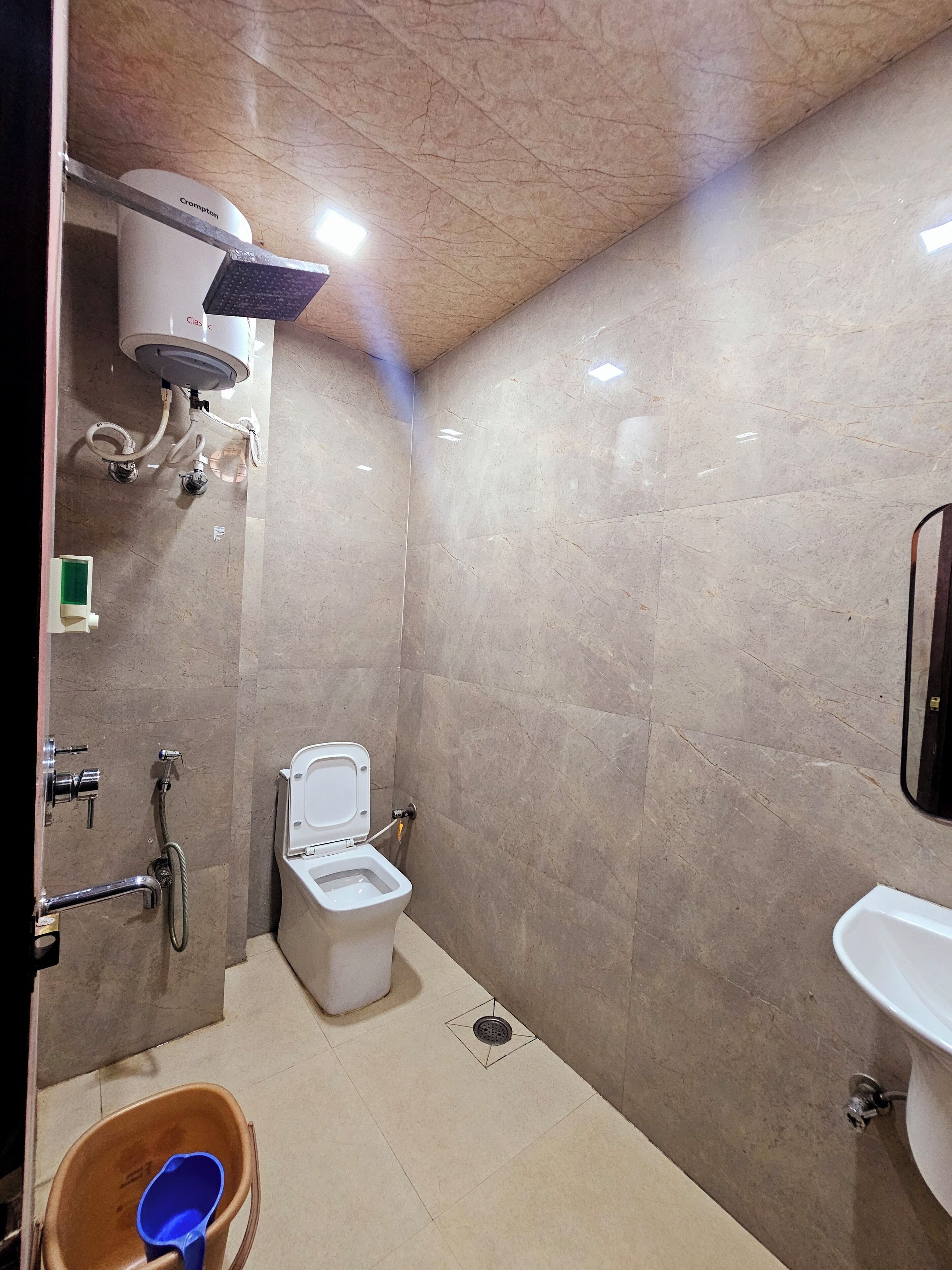 A small, modern bathroom with a toilet, shower, and sink.