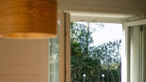 Un coin repas avec une table dressée pour deux personnes, une table en bois et une chaise.