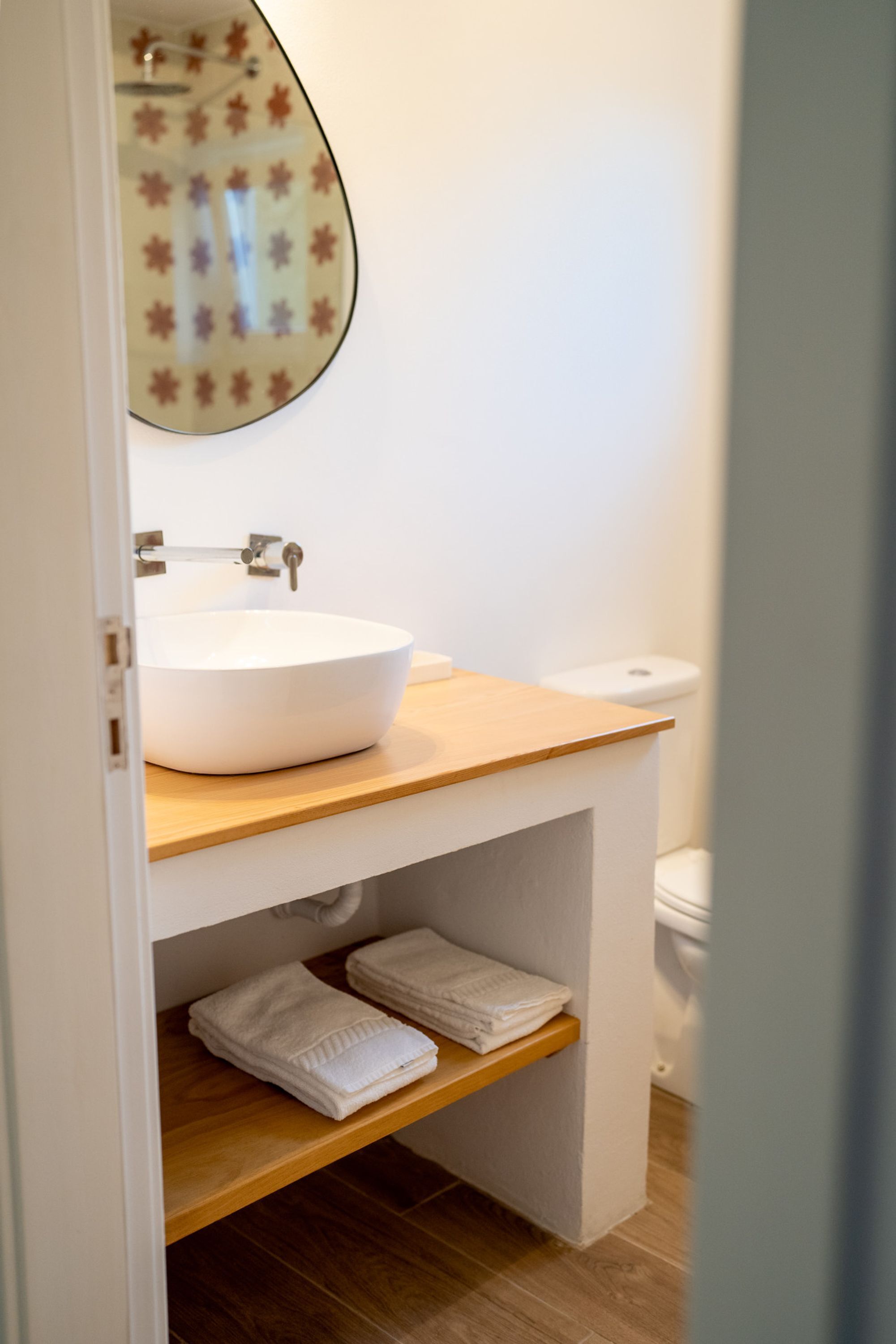 Une salle de bain moderne avec un lavabo blanc, un plan de toilette en bois et des toilettes.