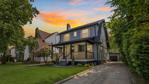A two-story house with a covered front porch, a garage, and a well-maintained lawn. - Stylish 3BR in Cleveland Hts |  Close to Clinic, UH (Cleveland Heights)