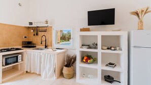 Une cuisine moderne équipée d’un four à micro-ondes, d’une cuisinière, d’un évier et d’un téléviseur à écran plat.