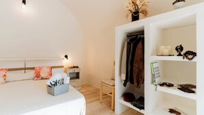 Une chambre à coucher comprenant un lit, une table de chevet, une chaise, une armoire et une étagère avec divers objets.