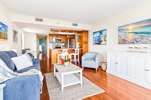 A modern living room with a sofa, a coffee table, and a dining area with chairs. - Beachside Ocean View Condo W/ Heated Pool, Hot Tub, & Private Balcony (Cape Canaveral)