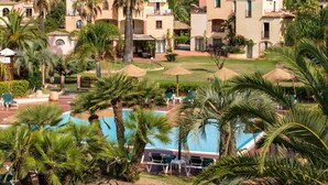 Un complexe hôtelier comprenant plusieurs villas, une piscine et une végétation luxuriante.