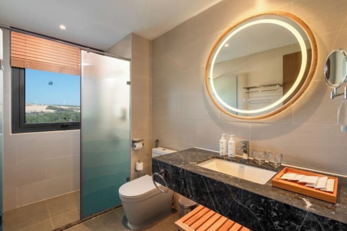 Un bagno moderno con uno specchio grande, un water e un lavandino.