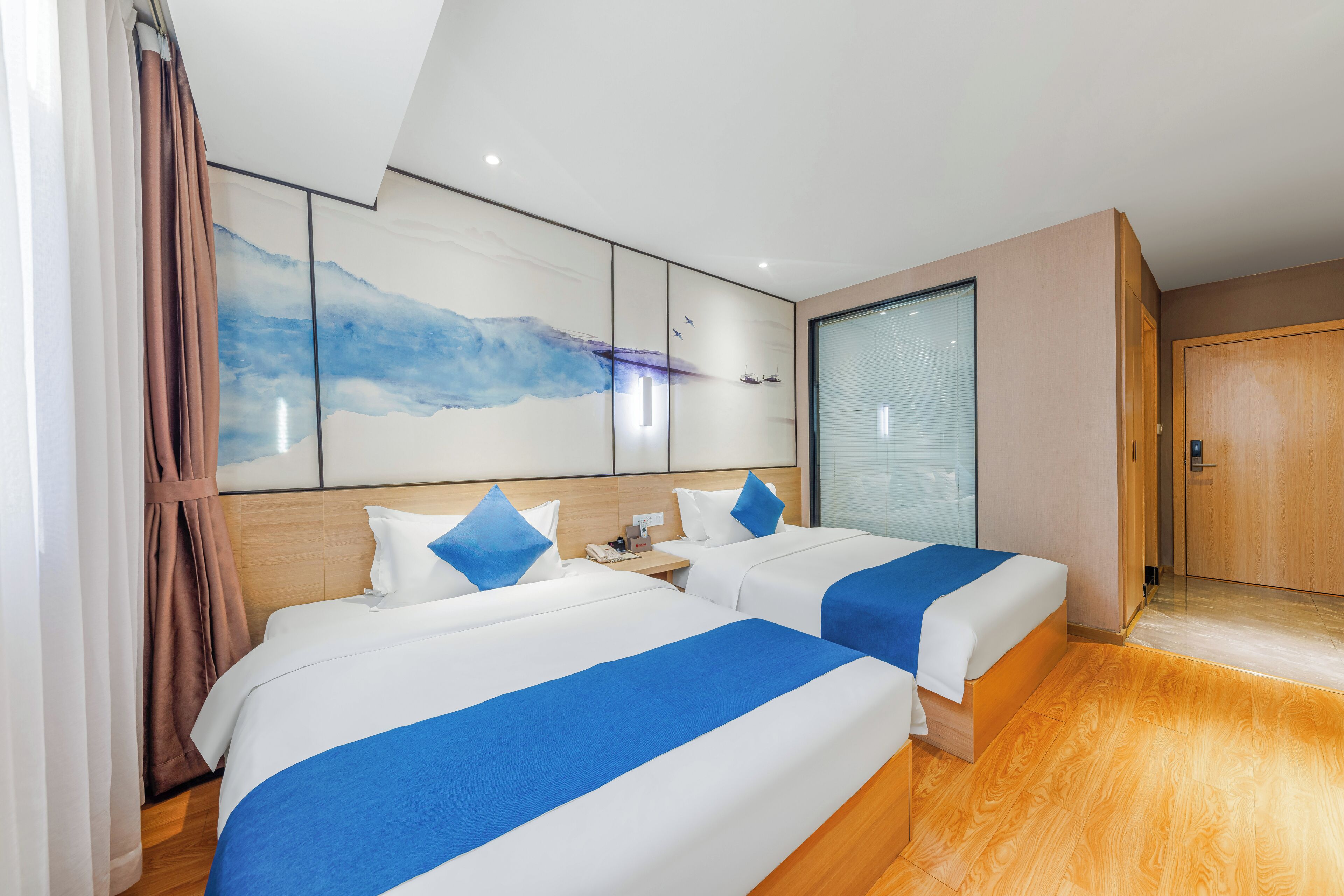 A hotel room with two beds, a large abstract painting on the wall, a wooden floor, and a sliding door.