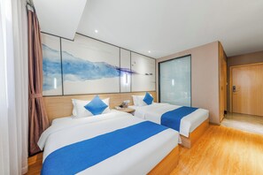 Ein Hotelzimmer mit zwei Betten, einem großen abstrakten Gemälde an der Wand, einem Holzboden und einer Schiebetür.