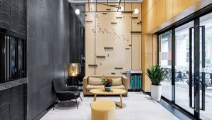 A modern lobby with a sofa, chairs, a coffee table, and a large window with a view of the street. - Guangzhou Hongcheng Hotel  (Guangzhou)