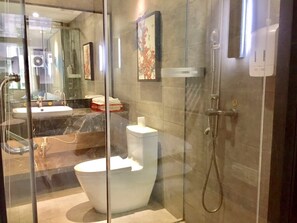 Luxe tweepersoonskamer | Badkamer | Een douche, een haardroger, pantoffels, handdoeken