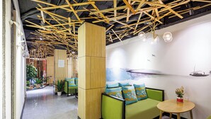 A modern interior with green seating, wooden ceiling beams, and a mural. - Guangzhou Hongcheng Hotel  (Guangzhou)