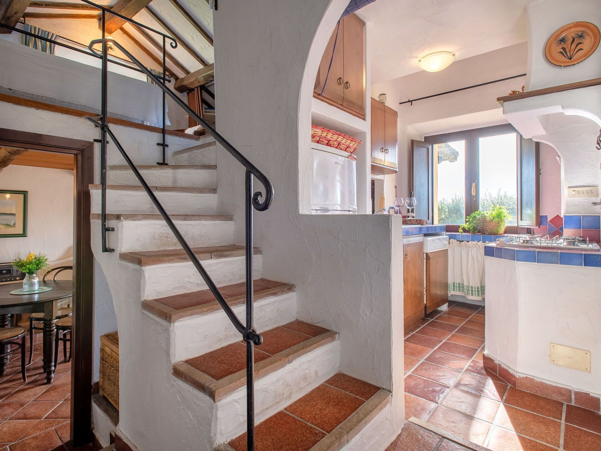A staircase leading to a kitchen with a view of the outdoors.