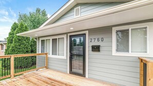 A two-story house with a wooden deck, a black front door, and the number 2760 on the wall. - Renovated Urban Oasis in Indy (Indianapolis)