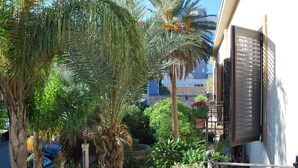 A residential area with palm trees, a fence, and a building with a balcony. - Volta House (Palermo)