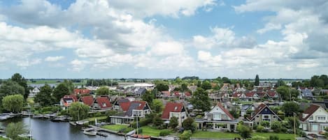 A residential area with houses, a canal, and boats.