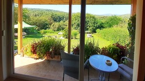 A balcony with a view of a lush green landscape, a table, and chairs. - Harmony of romance and nature for two, in a double bedroom (Miskolc)