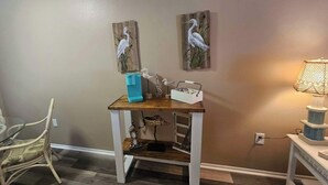 A room with a wooden table, a chair, wall art, and a lamp. - Professor Rousseau's Sea Turtle Sanctuary (Crystal River)