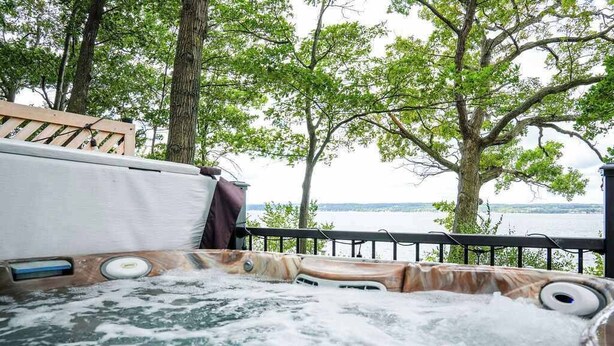 Un jacuzzi con vistas a un lago y árboles.