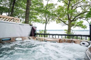 A hot tub with a view of a lake and trees. - Lakefront House: Hot Tub, Game Room & Wine Trail (Geneva)