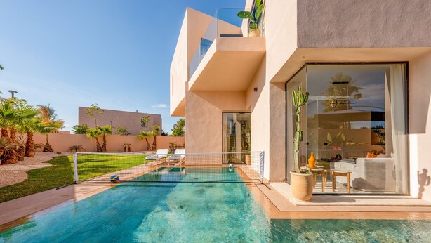 Une maison moderne dotée d’une piscine, d’un balcon et offrant une vue sur le paysage environnant.