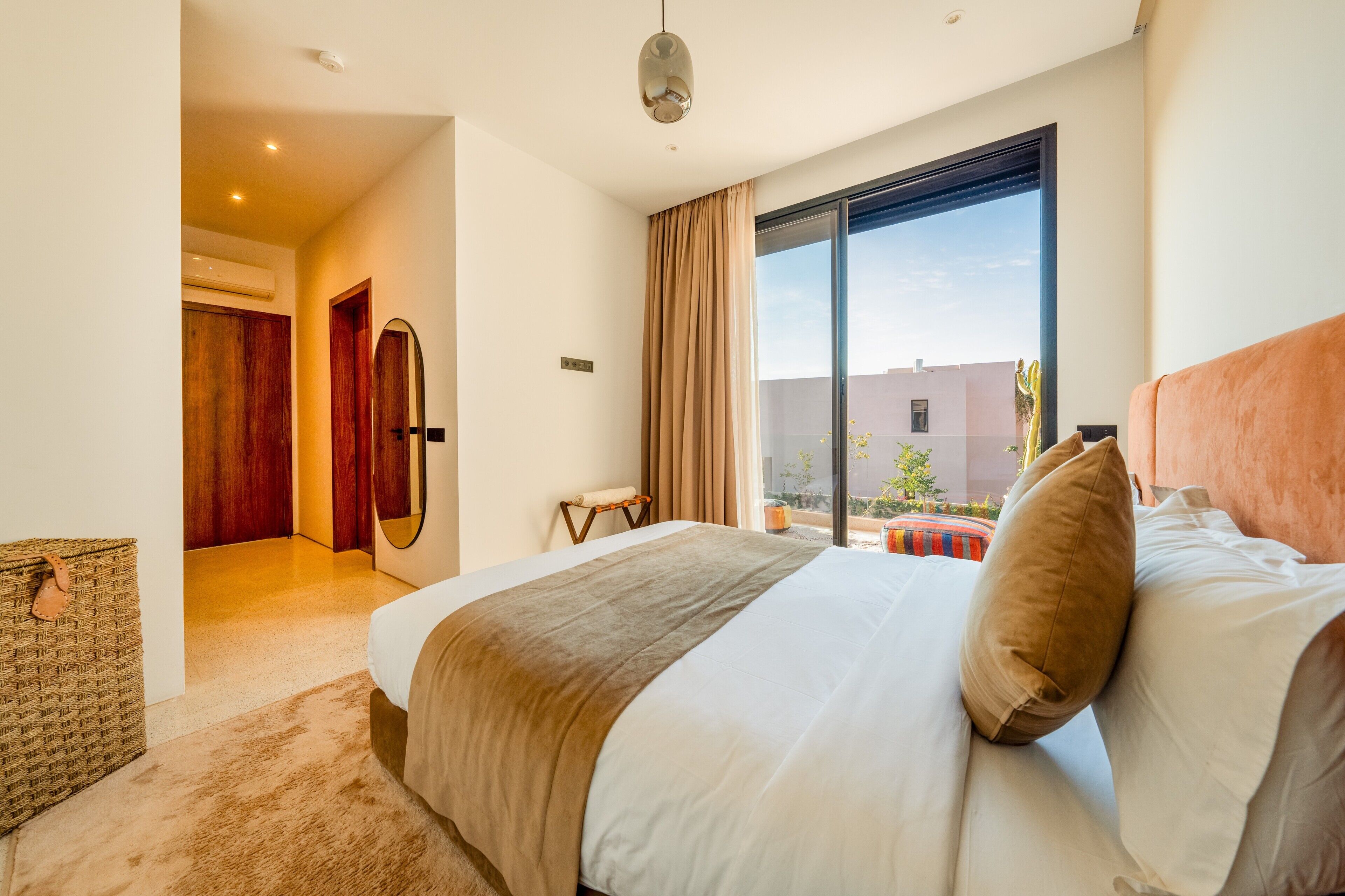 Ett modernt hotellrum med en stor säng, utsikt över omgivningarna och en liten sittgrupp.